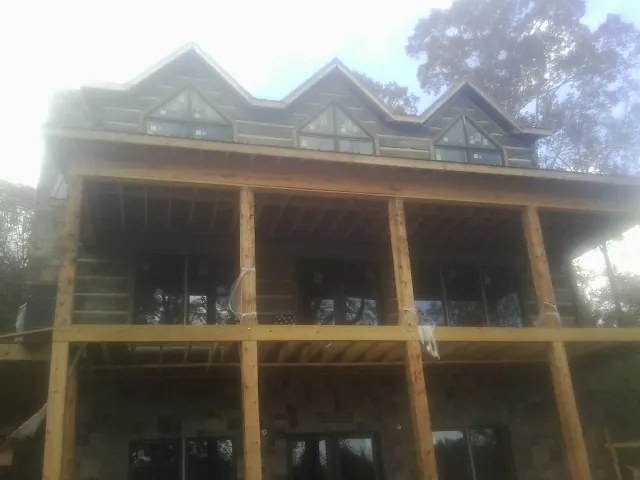 Dormers and porch framing on a large log home under construction — Roof Coating work by our crew in Holyoke