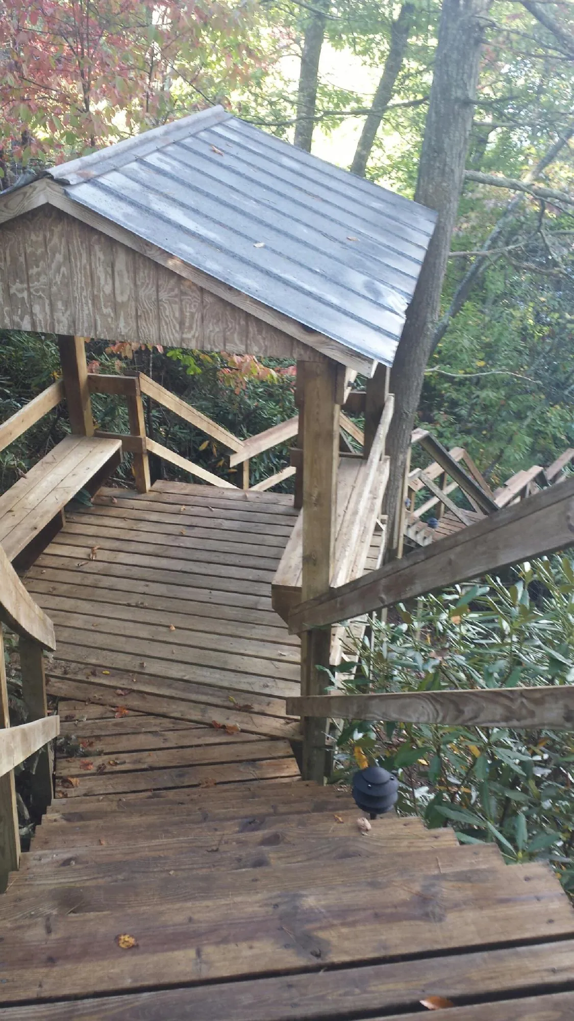 Metal roofed shelter over wooden steps on a wooded walkway — Skylight Repair & Installation work by our crew in Holyoke