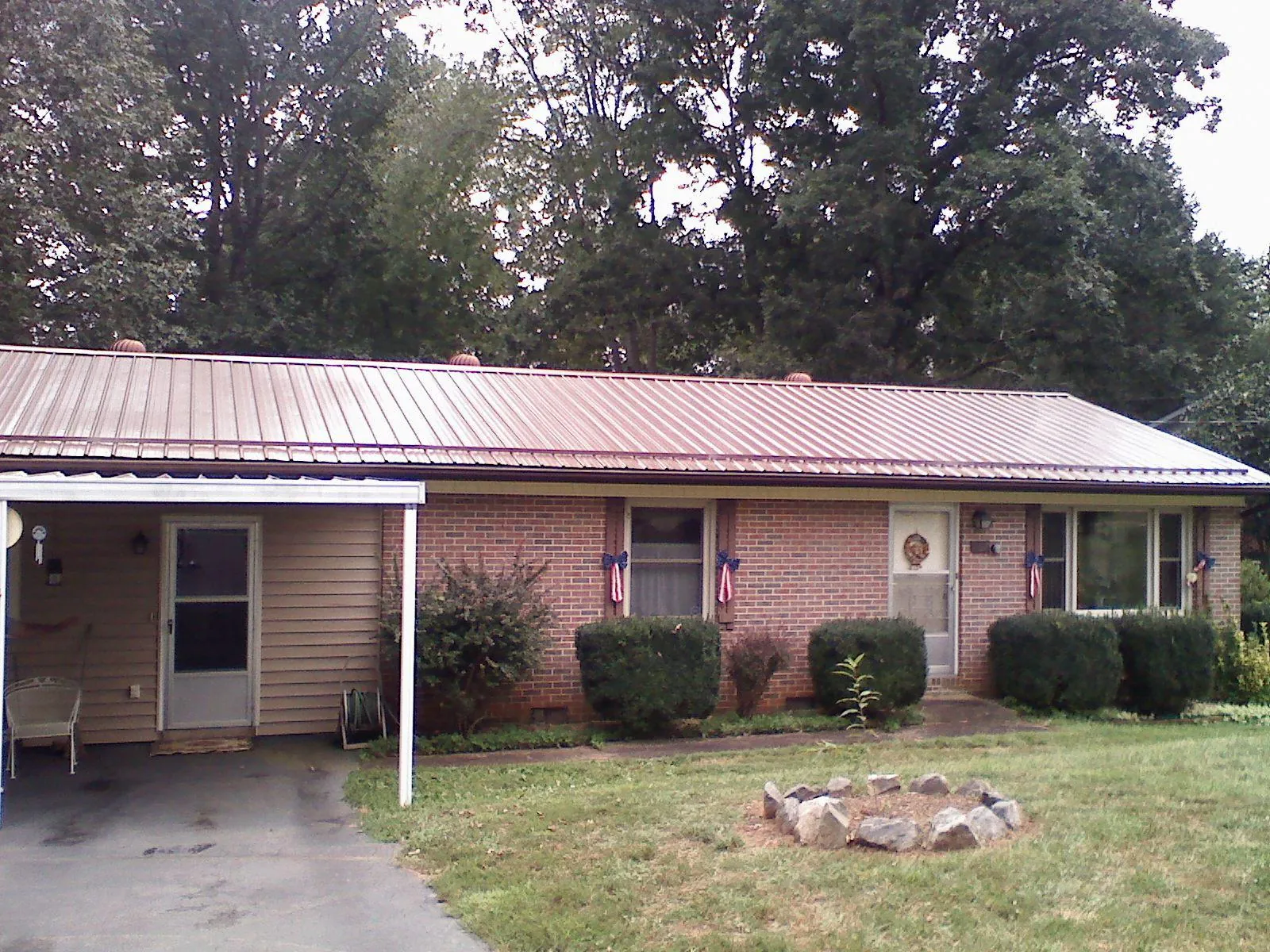 Bronze metal roof and carport on a brick ranch home — Roof Repair work by our crew in Holyoke
